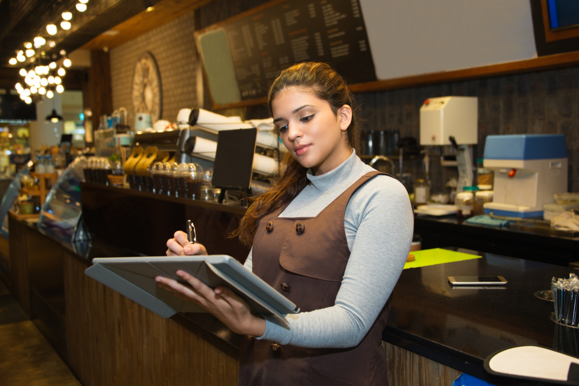 Confident Cafe Owner Writing Register Book
